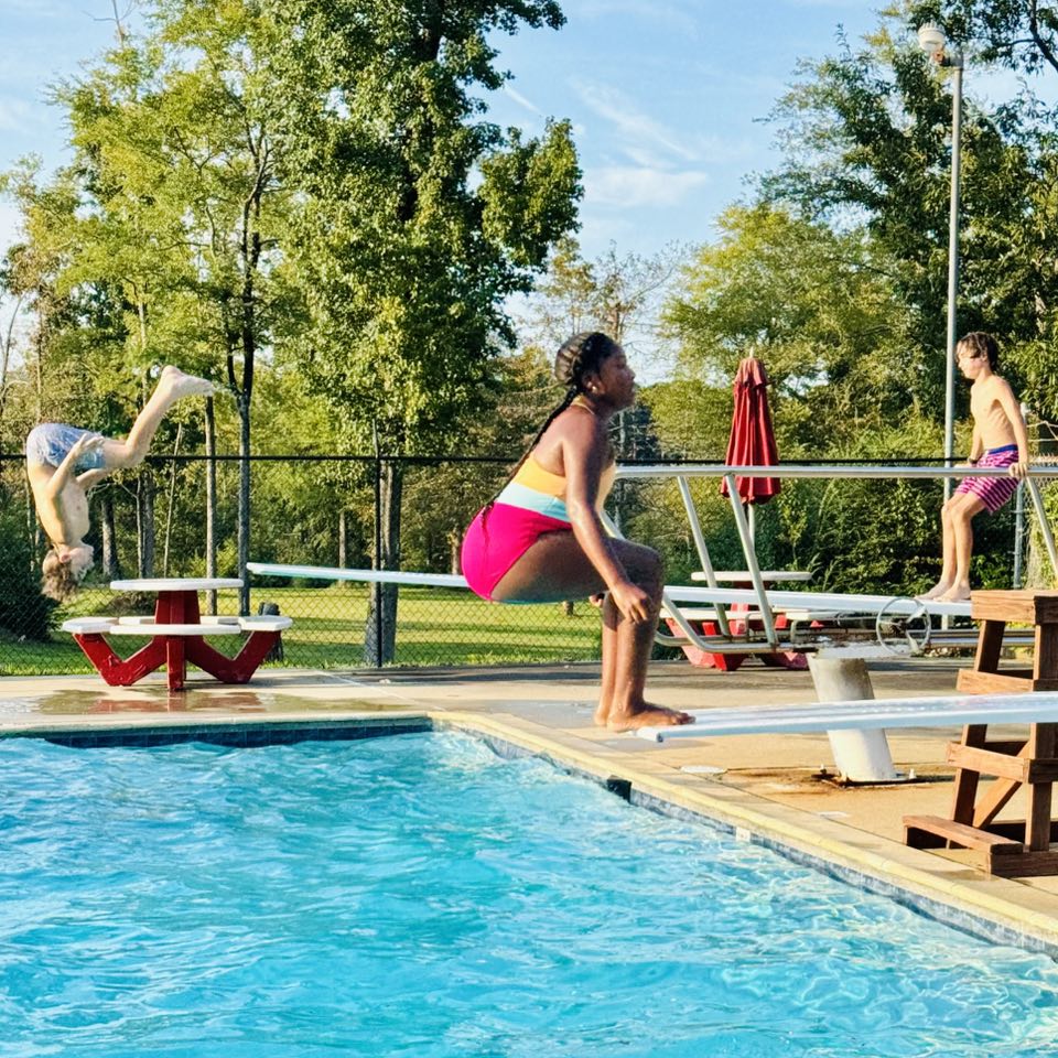 A girl about to do a backwards flip off a diving board.